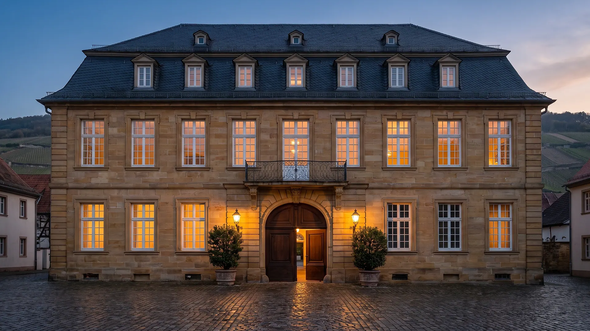Ein barockes Stadtpalais aus Sandstein zur blauen Stunde, die Sprossenfenster warm erleuchtet (KI-generiertes Symbolbild)